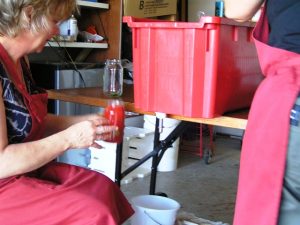 Filling a jar with freshly made tomato sauce