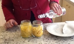 Pour alcohol into the jar with the lemon skin